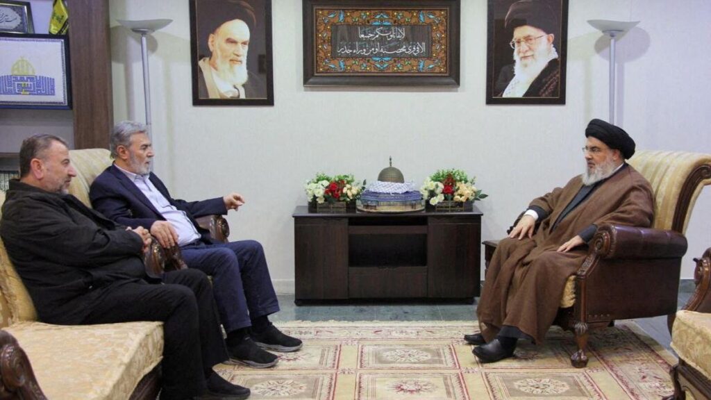 ο επικεφαλής της Hezbollah στον Λίβανο, Sayyed Hassan Nasrallah (δεξιά) σε συνάντηση με τον γενικό γραμματέα της Παλαιστινιακής Ισλαμικής Τζιχάντ (PIJ), Ziyad al-Nakhalah και τον αναπληρωτή αρχηγό της Χαμάς, Sheikh Saleh al-Arouri (δεύτερος αριστερά, με τα μαύρα) σε μυστική τοποθεσία στις 25 Οκτωβρίου 2023 / Reuters > στον τοίχο οι φωτογραφίες του πρώτου ανώτατου ηγέτη του Ιράν, Ayatollah Khomeini (1979 - 1989, αριστερά) και του δεύτερου, εν ενεργεία από το 1989, Ali Khamenei (δεξιά)